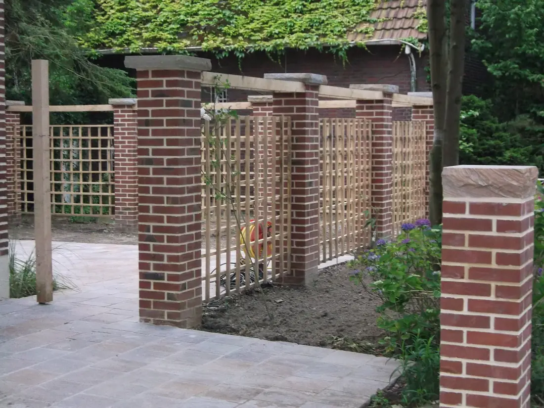 Gemauerte Klinkerpfeiler mit Holzrankgittern als Sichtschutz